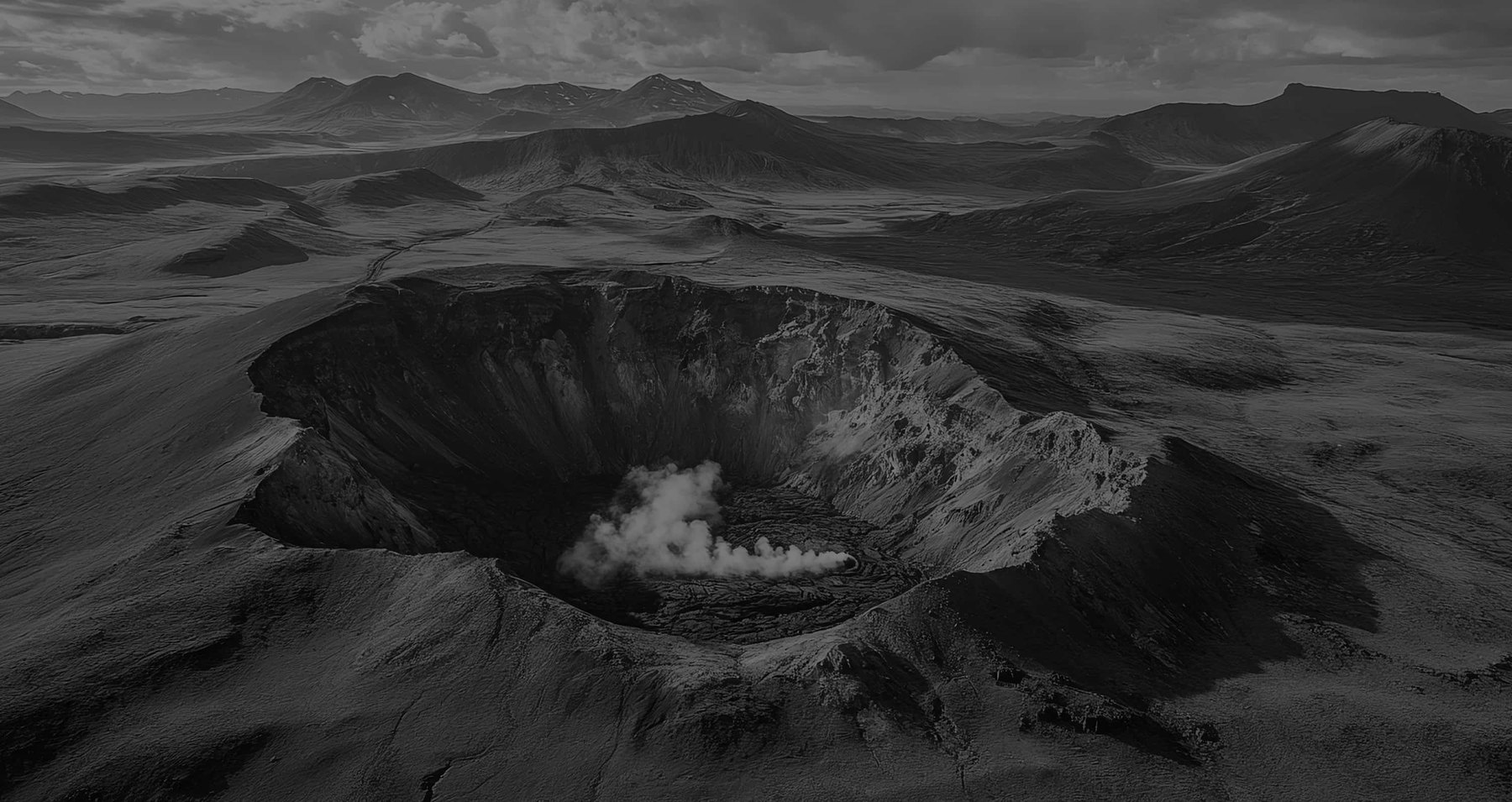 Aerial black and white view of a volcanic caldera landscape.