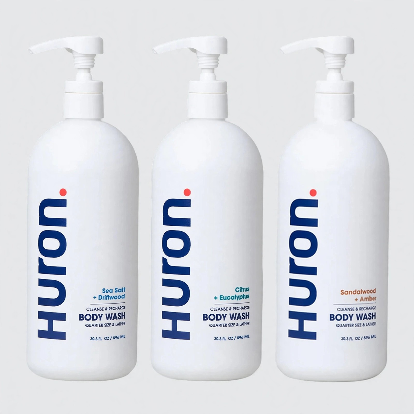 Three white Huron Body Wash bottles against gray background.