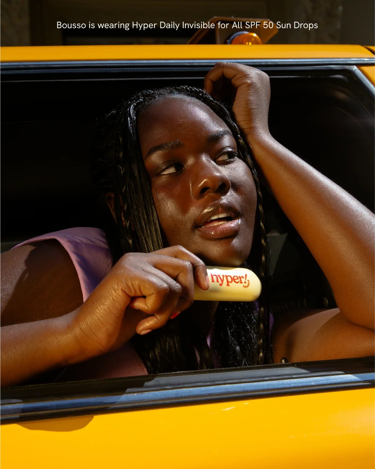 Woman leaning from taxi holding Hyper product bottle.