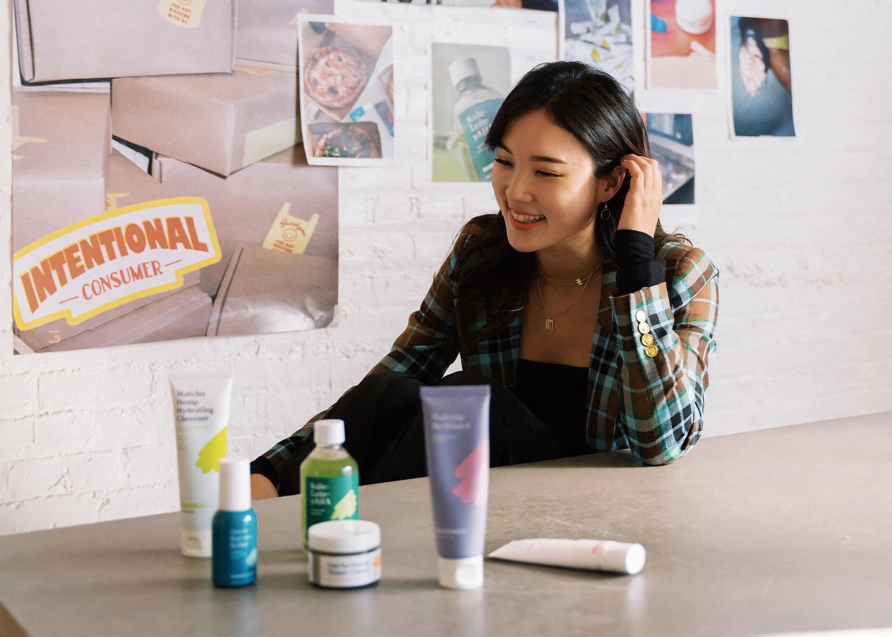 Liah Yoo seated at a table with KraveBeauty products displayed.