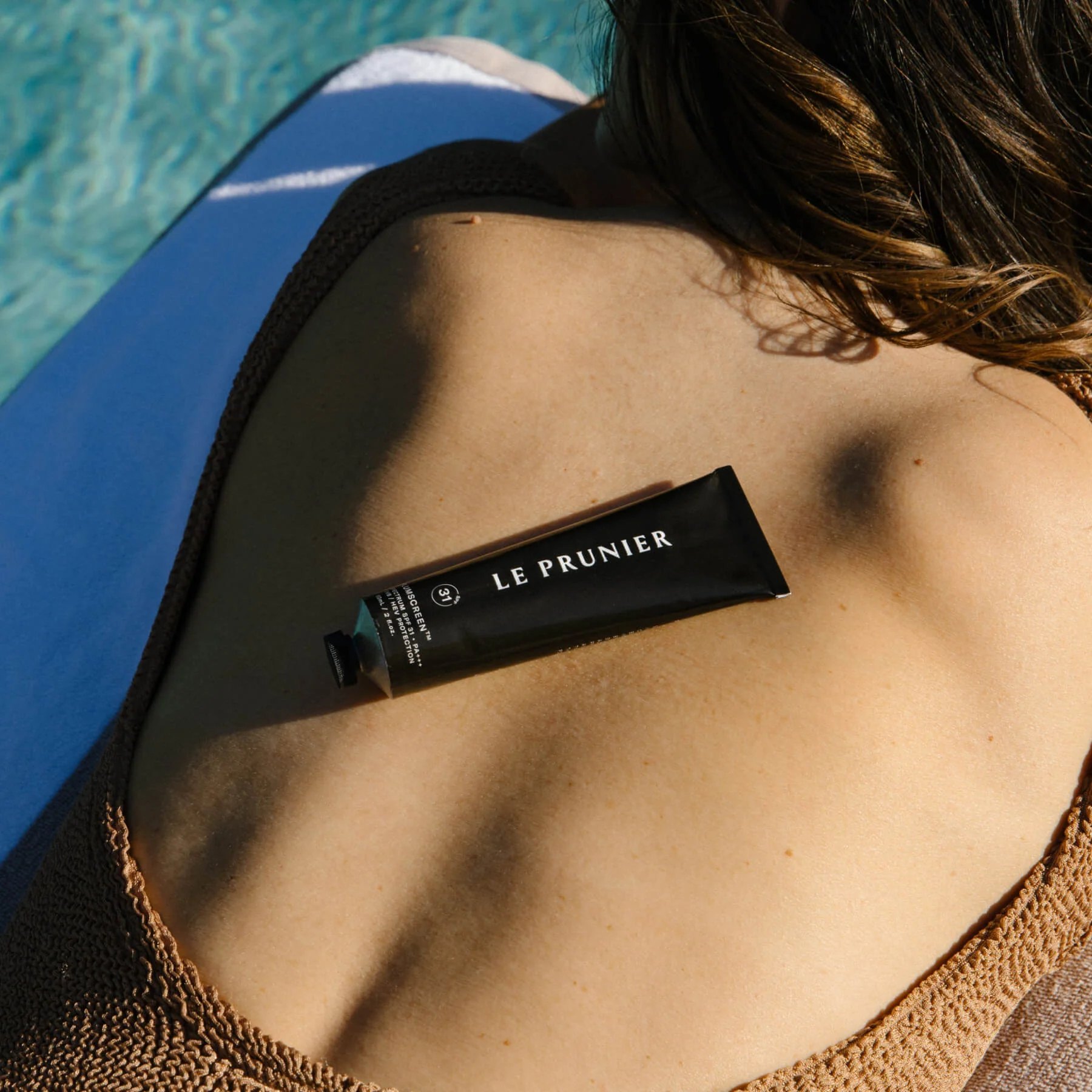 Plumscreen tube on a woman's back by pool.