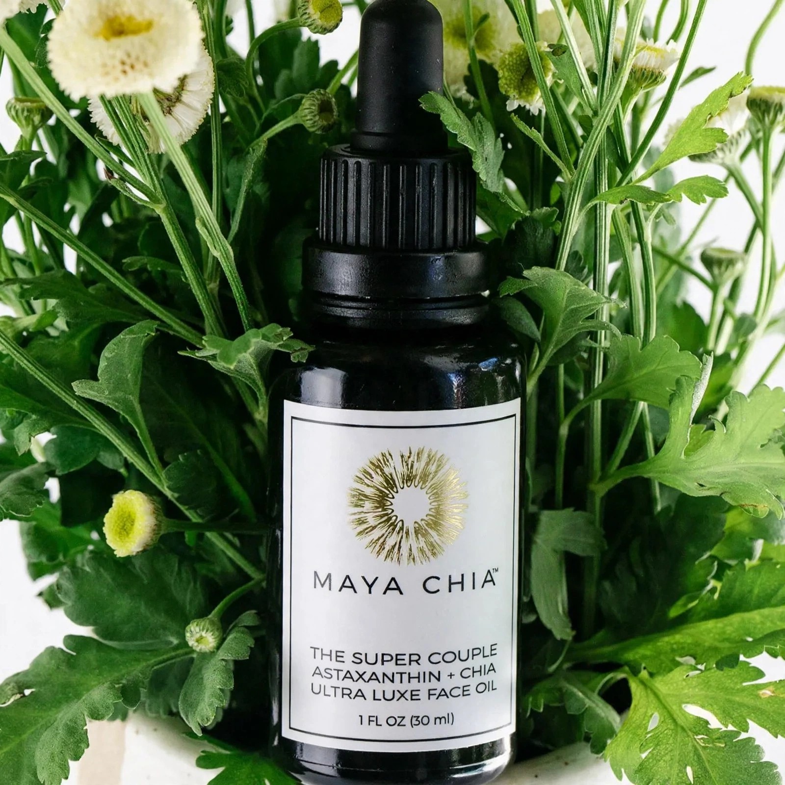 Maya Chia The Super Couple bottle among green foliage.